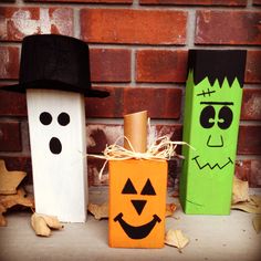 three wooden blocks decorated to look like pumpkins, ghost and jack - o'- lantern