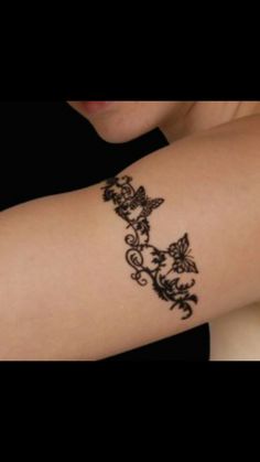 a woman's arm with a tattoo design on the side of her left arm