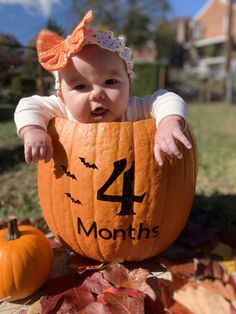 a baby sitting in a pumpkin with the number four on it