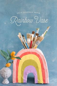 a rainbow vase with paint brushes in it