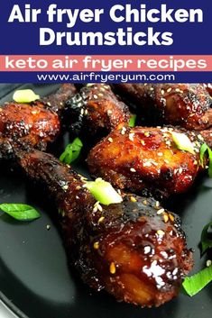 air fryer chicken drumsticks on a black plate with green garnish