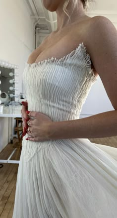 a woman in a white dress is holding her hand on her hip