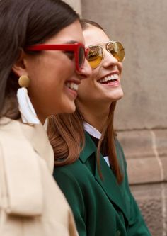 two women wearing sunglasses are smiling for the camera