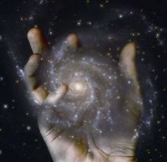 a person's hand holding up a spirally object in the dark night sky