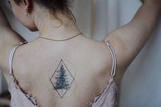 a woman with a pine tree tattoo on her back