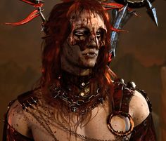 a close up of a person with red hair and chains around their neck, wearing an elaborate costume