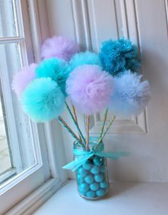 a vase filled with blue and pink pom - poms