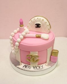 a cake that is shaped like a purse and has lipstick on it, with pearls around the edges