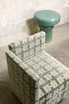 a chair and stool sitting next to each other on the floor in front of a wall