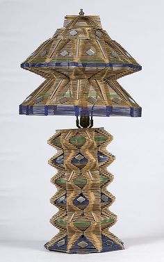 a table lamp made out of strips of wood with a blue glass shade on top