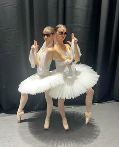 two ballerinas in white tutus posing for the camera