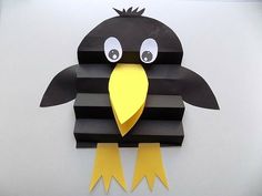 a paper cut out of a black bird with yellow beak