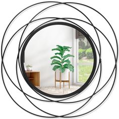 a round mirror reflecting a houseplant in it's centerpiece, next to a wooden table