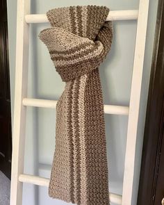 a brown and white scarf hanging on a ladder