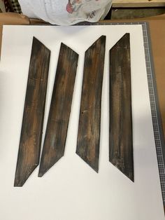 three pieces of wood sitting on top of a white table next to a cardboard box