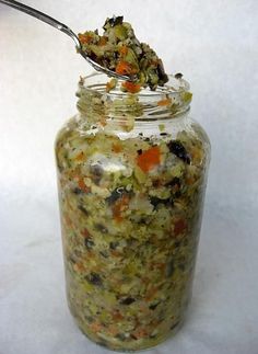 a jar filled with food and a spoon full of some kind of stuff in it