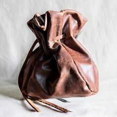 a brown leather purse with a long handle