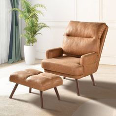 a chair and ottoman in a room with a potted plant on the far wall