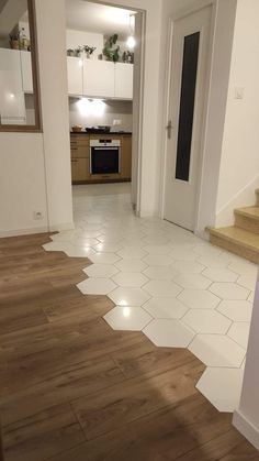 an empty room with wooden floors and white walls, in the middle of a house