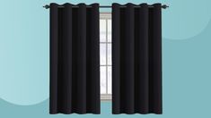 a black curtain hanging on the side of a window in front of a blue wall