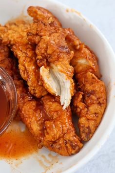 a white bowl filled with fried chicken and sauce