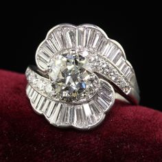 an antique diamond ring on top of a red velvet cushion