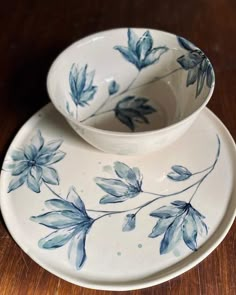 two blue and white dishes sitting on top of a wooden table