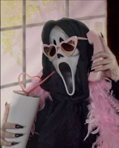 a woman in a mask holding a drink and drinking from a cup with a straw