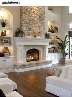 a living room with white furniture and a fireplace