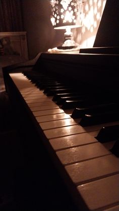 an old piano in the dark with light coming from it's top and back