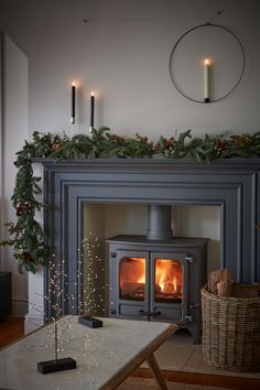 a living room with a fire place next to a christmas wreath on the fireplace mantel