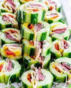 cucumber rolls with meat, cheese and herbs on a platter ready to be eaten