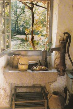 an old fashioned sink in front of a window with the sun shining on it and trees outside