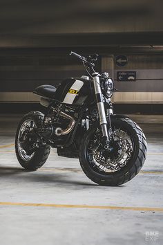 a black motorcycle parked in a parking garage