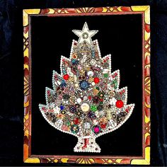 a christmas tree made out of buttons in a wooden frame on a black cloth background