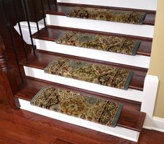 a set of stairs with rugs on the bottom and bottom treads in front of them