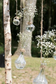 hanging glass vases filled with baby's breath flowers are the perfect way to decorate your outdoor space