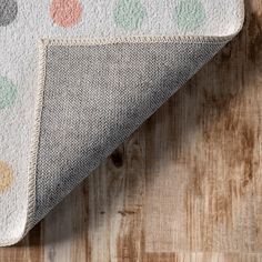 a white and green polka dot rug on top of a wooden floor