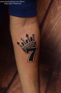 a man with a crown tattoo on his arm