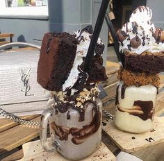 two ice cream sundaes with chocolate and marshmallow toppings on top