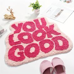 a pair of pink slippers next to a rug that says you got good on it