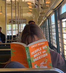 a person sitting on a bus reading a book