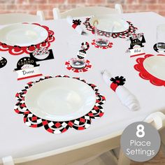 the table is set with red and black plates, napkins, and place settings