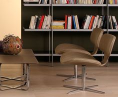 two chairs and a table in front of bookshelves