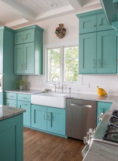 a kitchen filled with lots of blue cabinets and counter top space next to a stove top oven