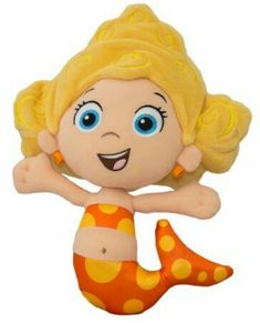 a stuffed toy mermaid with blue eyes and blonde hair, sitting on its back legs