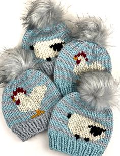 three knitted hats with pom - poms on the top and one has an image of a chicken