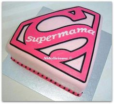 a pink cake with the word superman written on it