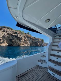 there is a boat that is going down the water and some rocks in the background