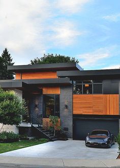 a car is parked in front of a house with wood paneling on the windows